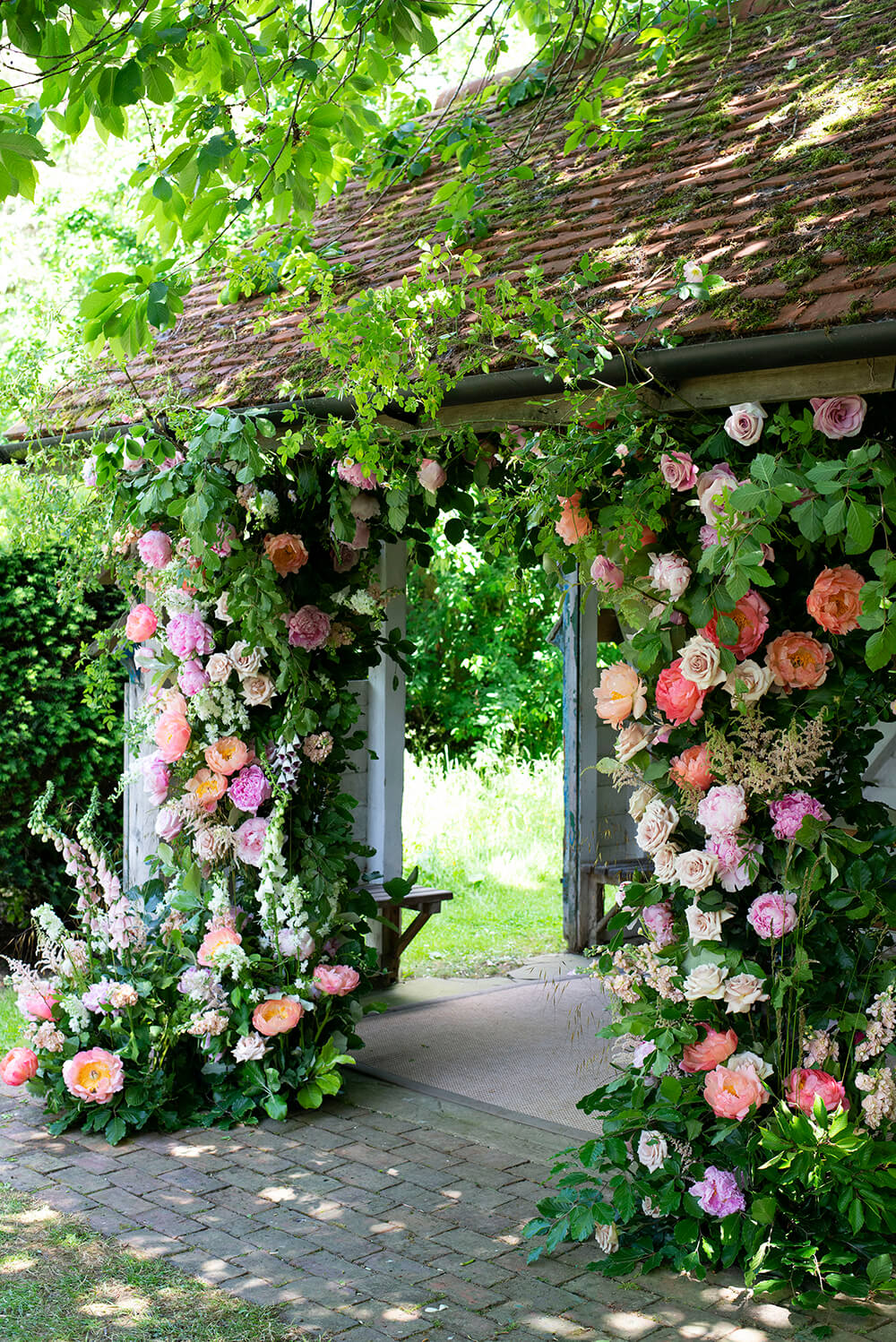 Wooden shelter with roses foxgloves and dahlia doorway